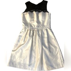 White cocktail dress with black lace detail shoulders. Size 6.